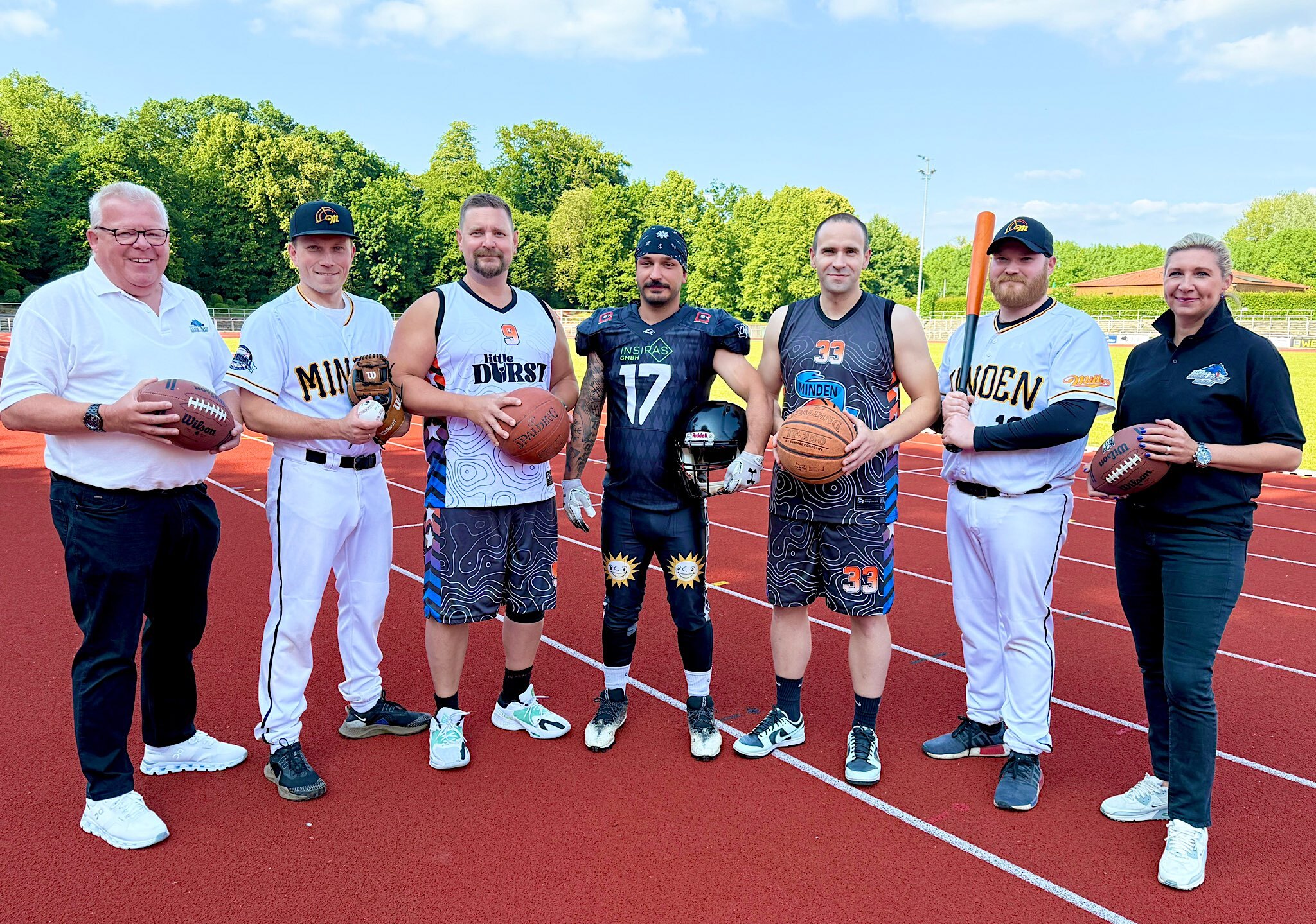 Richten am 4. Juli gemeinsam den American Sports Day aus: (v.l.n.r.) Volker Krusche (Minden Wolves), Dennis Hasfeld (Minden Millers), Ben Stumpf (Minden Movers), Guliano Schunke (Minden Wolves), Sebastian Nowak (Minden Movers), Justin Bade (Minden Millers) und Julia Fromlowitz (Minden Wolves).Foto: Anna-Lena Wiegmann/Indigo